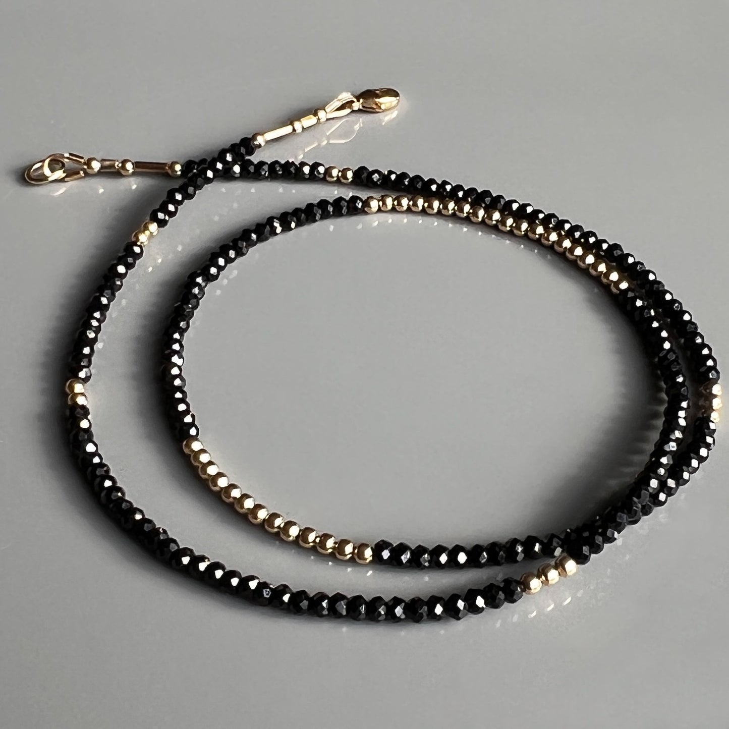 Luxurious 14K gold and faceted black spinel necklace, designed to add sophisticated elegance to any outfit, perfect for layering or wearing solo.