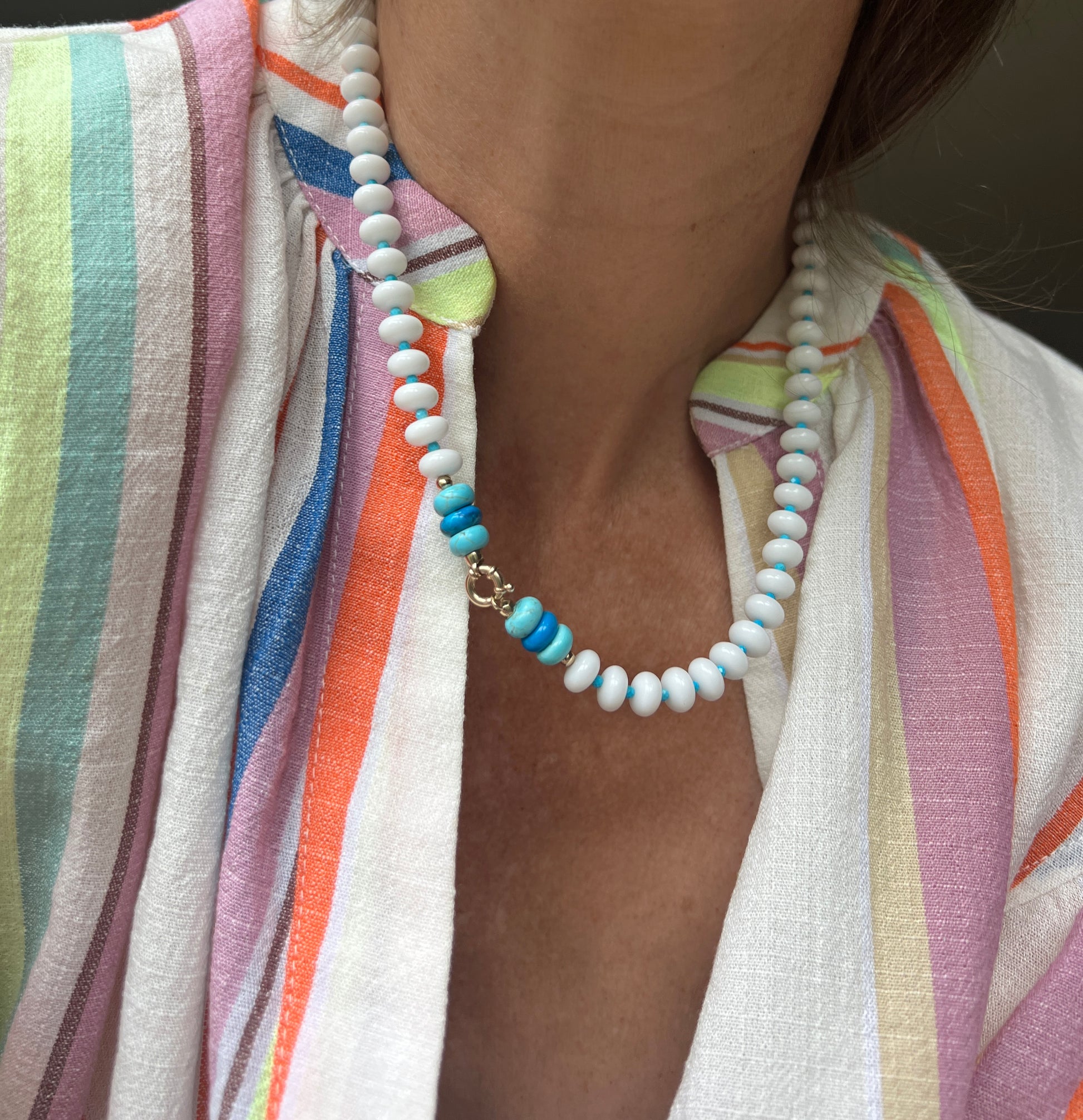 A statement necklace made with hand-selected white onyx, turquoise, and howlite beads, paired with an elegant clasp.