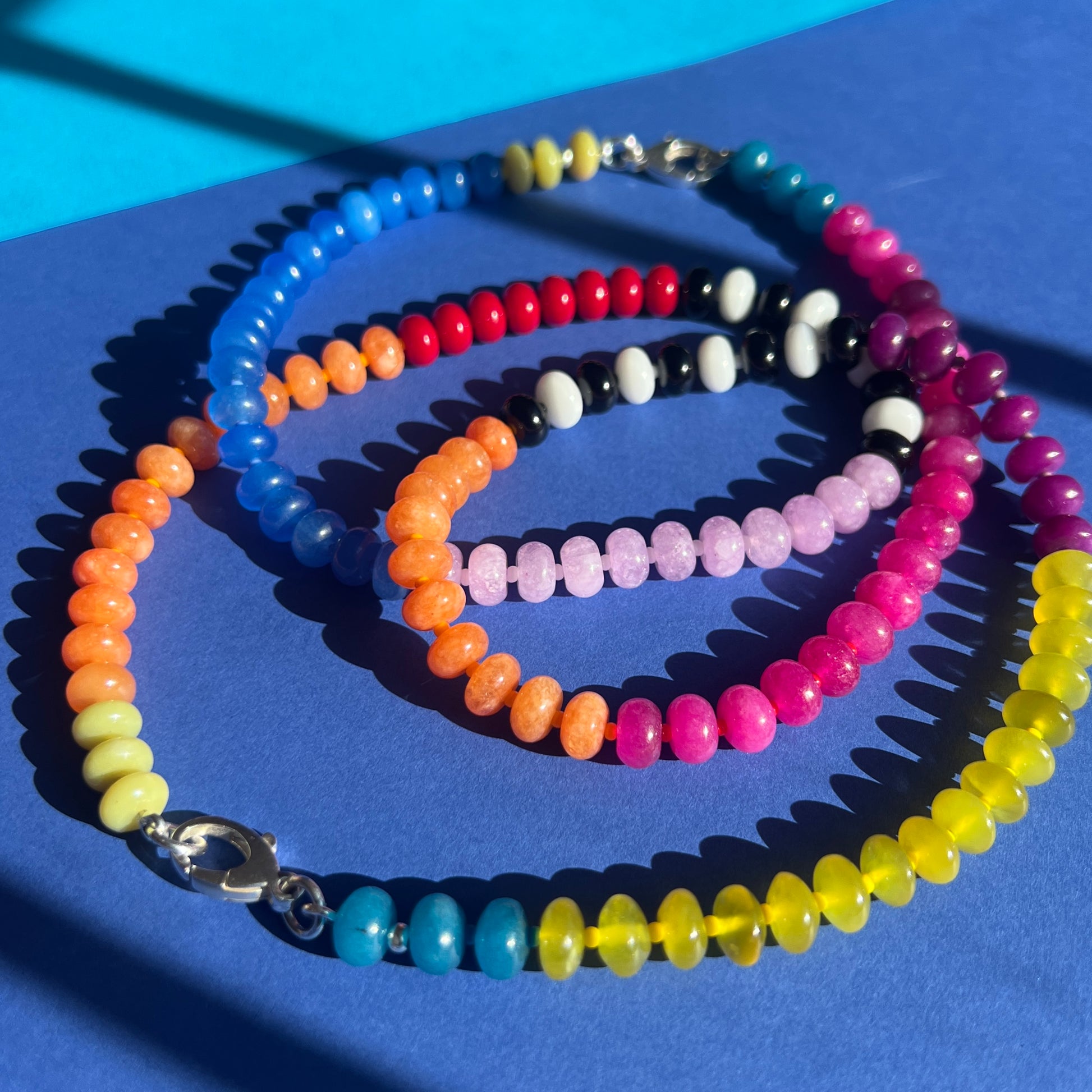 A statement necklace with 8mm gemstones, including jade, onyx, and chalcedony, interspersed with colorful Czech glass beads and finished with a secure clasp.