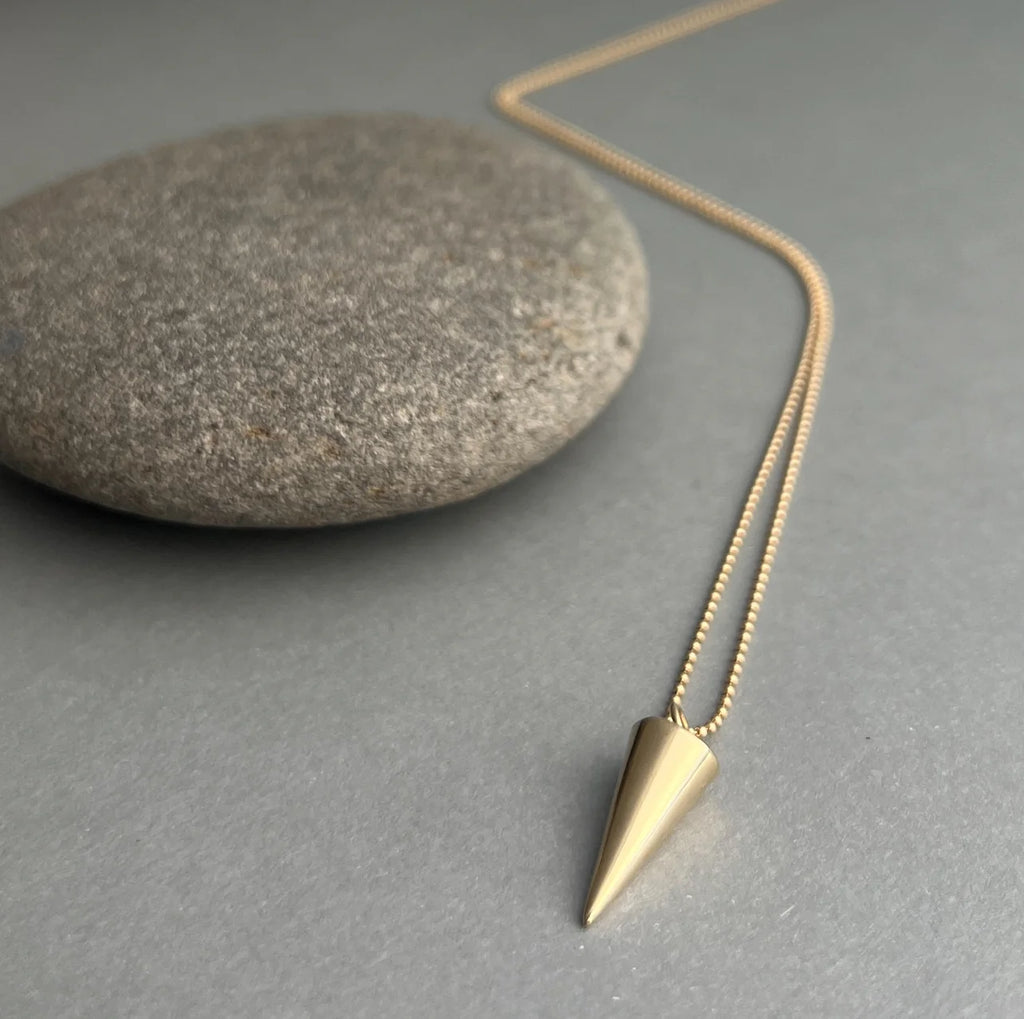 The Zenith Necklace features a downward-pointing triangle, symbolizing femininity, intuition, and the grounding forces of nature. Crafted from 14K gold or sterling silver for timeless elegance.