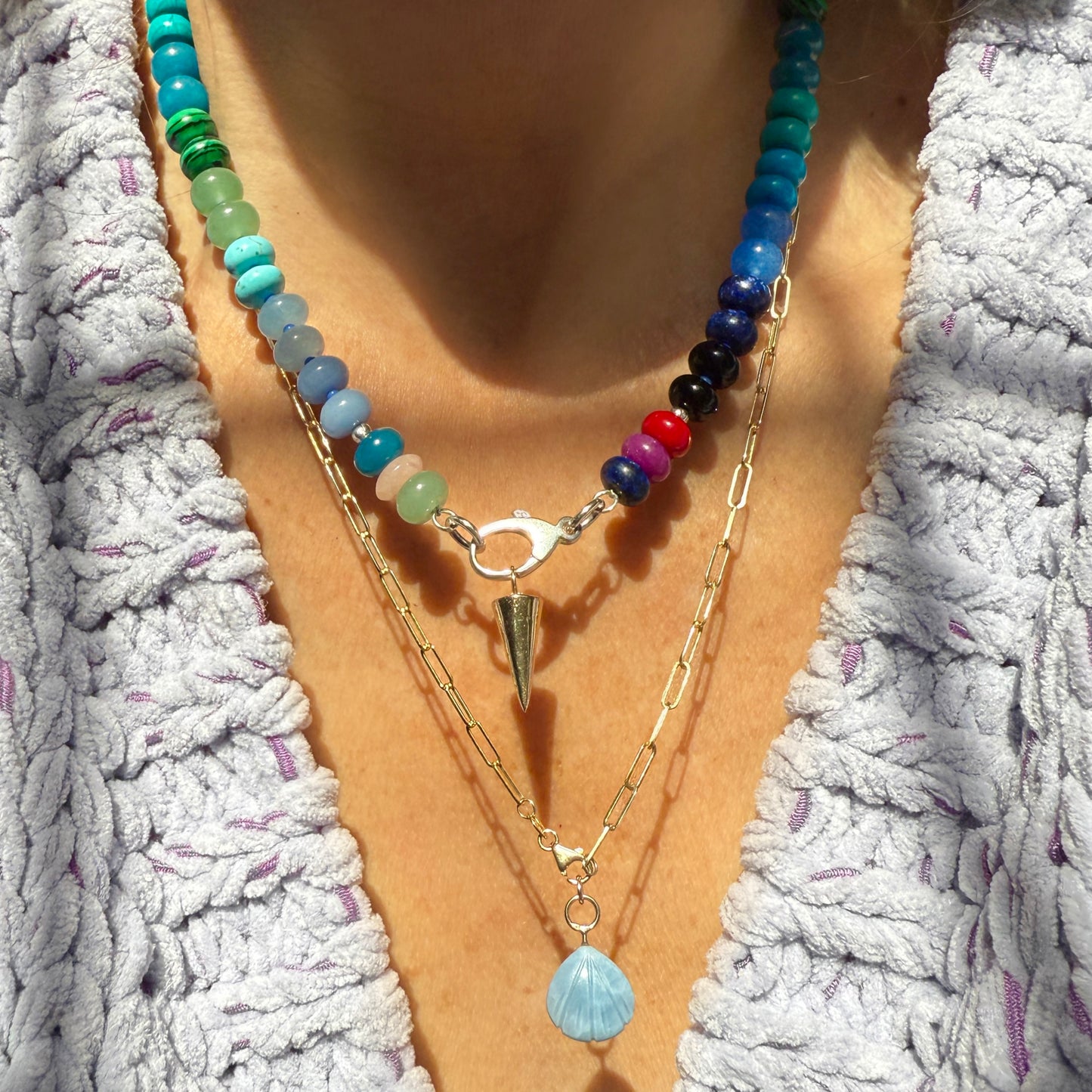 Model wearing a colorful handcrafted gemstone necklace with 8mm opals, jade, turquoise, and more, accented with Czech glass beads and a sterling silver clasp.