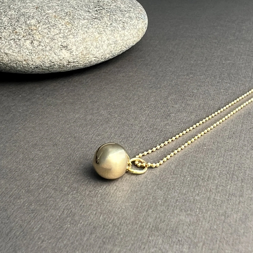 The Sphere Pendant, crafted from solid 14K gold, symbolizes completeness and unity, combining elegant form with timeless beauty.