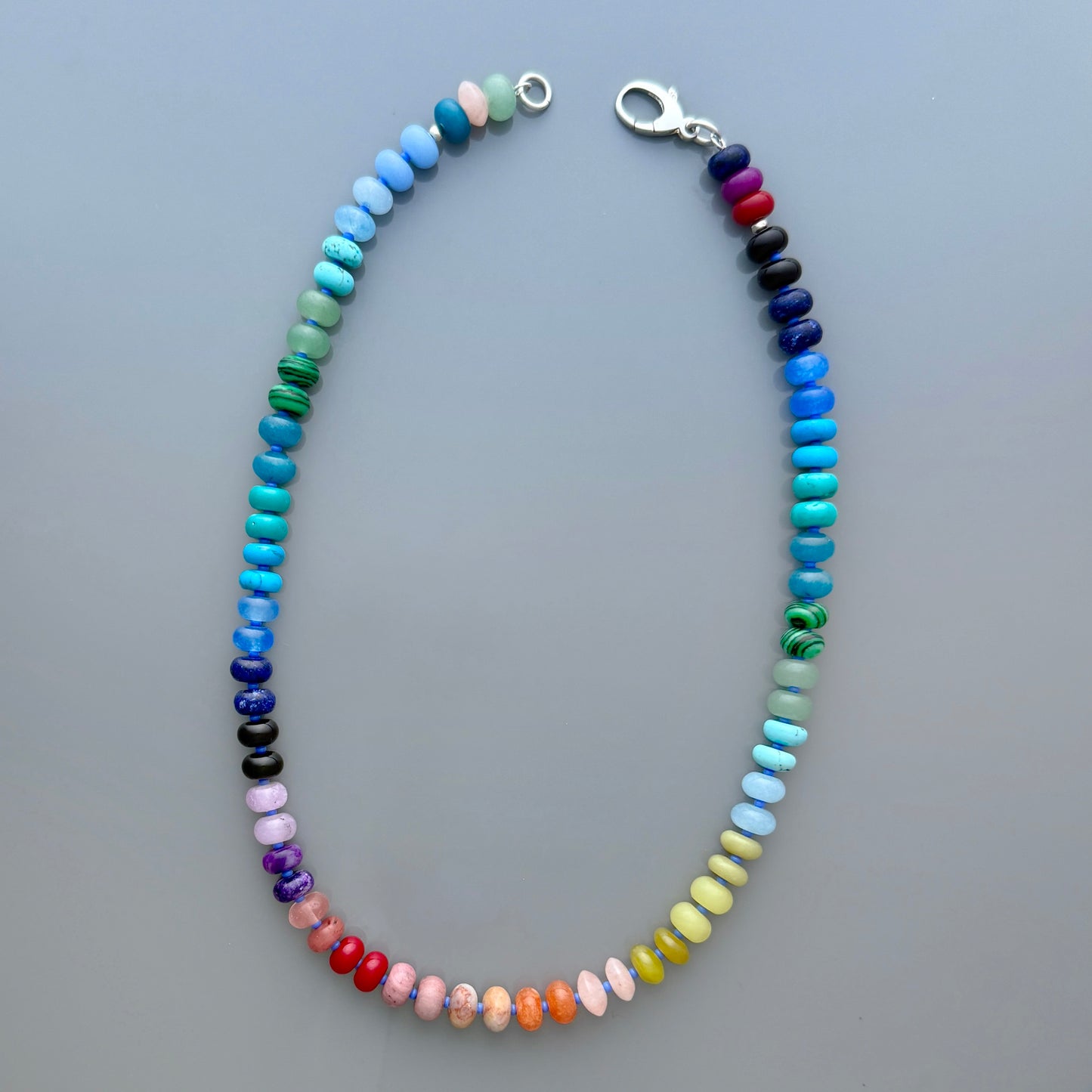 Handcrafted gemstone necklace with 8mm opals, jade, turquoise, and more, accented with Czech glass beads and a sterling silver clasp, perfect for layering or solo wear.