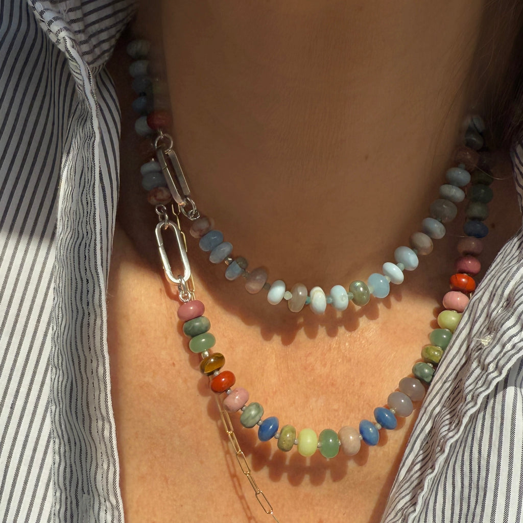 This Eclipse Natural Gemstone Beaded Necklace, made with Chalcedony, Tiger Eye, Jade, Jasper, and Quartz, allows for personalization with a 14K gold or sterling silver clasp and charm option.