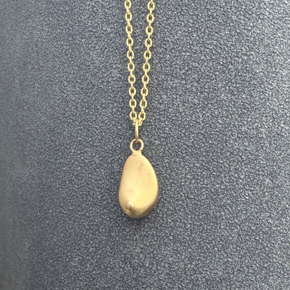Minimal gold anatomical necklace photographed in natural light