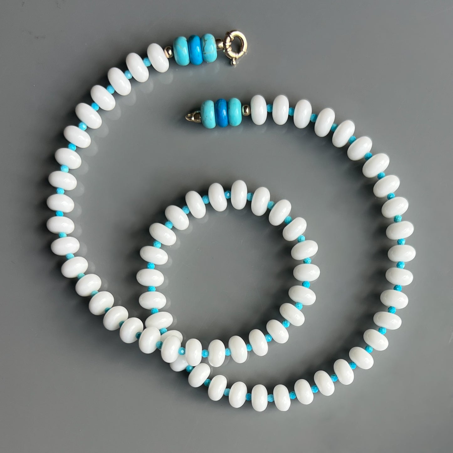 A chic necklace featuring white onyx, turquoise, and howlite beads, with a choice of 14k gold or sterling silver clasp.