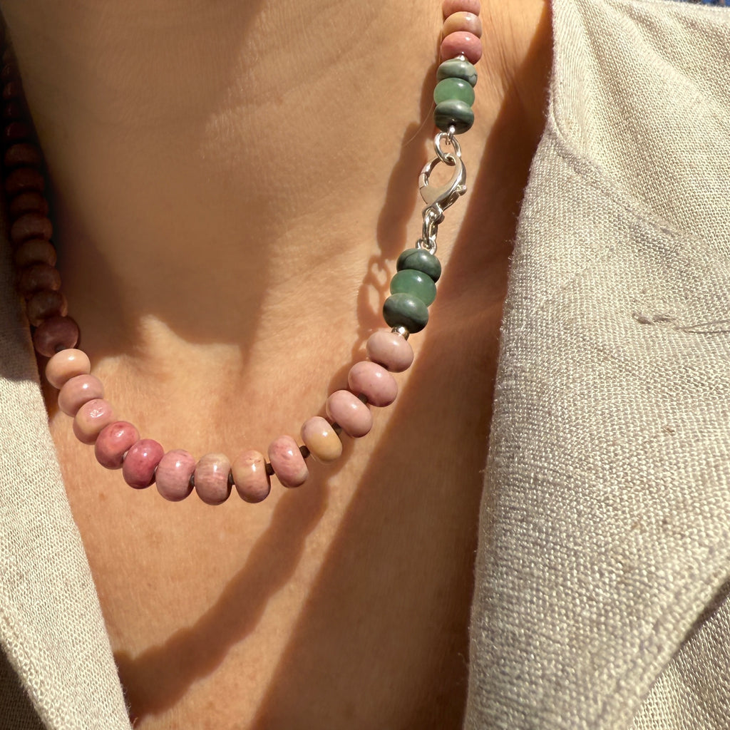 Model wearing a handcrafted gemstone necklace featuring rhodonite, aventurine, and jasper gemstones, accented with Czech glass spacer beads and finished with a 14k gold or sterling silver clasp. A versatile and unique piece, perfect for layering or wearing as a statement accessory.