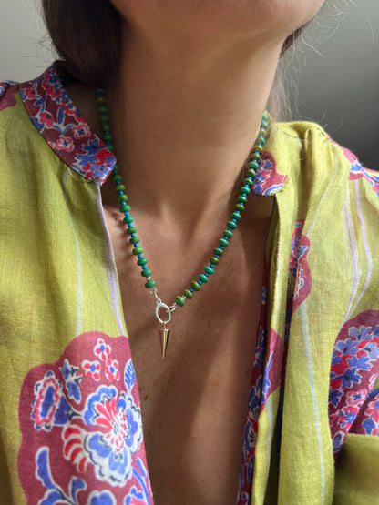 A model wearing a vibrant turquoise and green beaded necklace, elegantly styled to highlight its fresh and earthy tones.