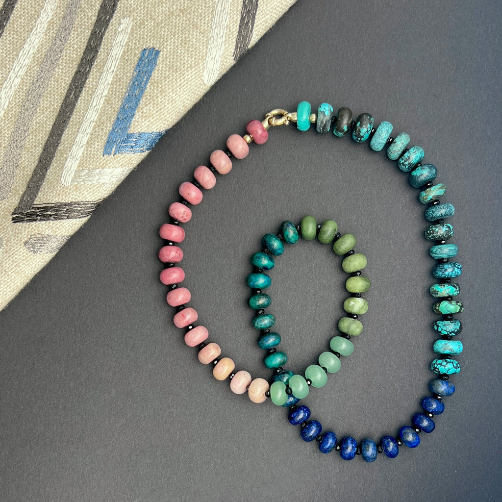 Handcrafted gemstone necklace with pink rhodonite, green aventurine, turquoise, and lapis lazuli beads, finished with a gold clasp.