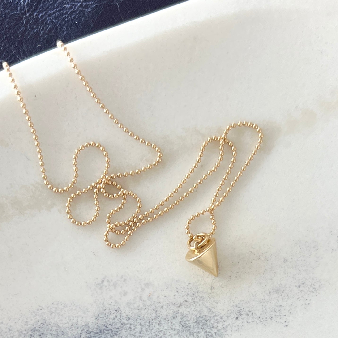 This handcrafted Zenith Petite Necklace in solid 14K gold or sterling silver channels energy and embodies growth. Its triangle shape represents unity, balance, and the flow of life.