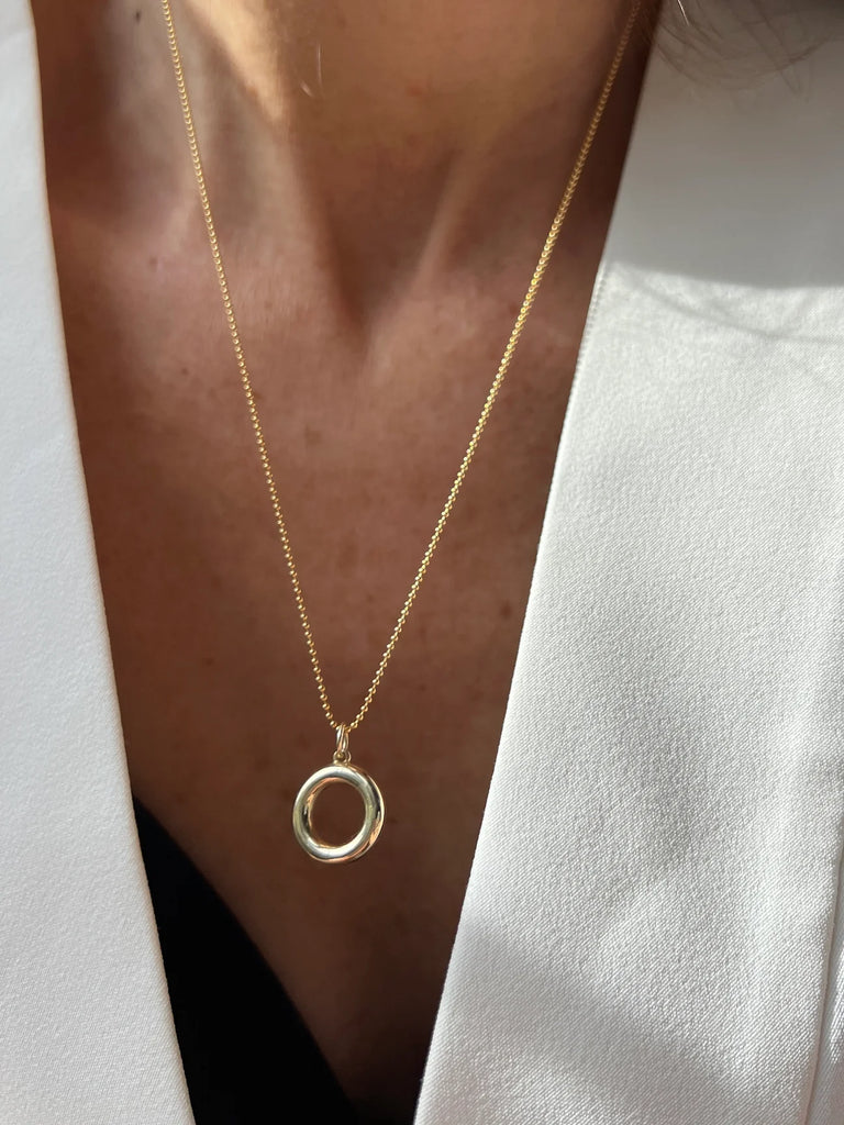 A sleek, circle-shaped charm in 14K gold represents resilience and stability. The perfect blend of elegance and symbolism, this necklace is a modern talisman for strength.