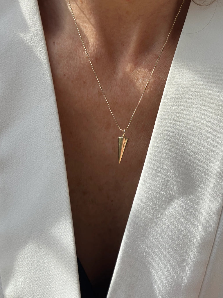 Crafted from solid 14K gold, the Zenith Necklace represents renewal, creativity, and the cyclical nature of life with its downward-pointing triangle charm.