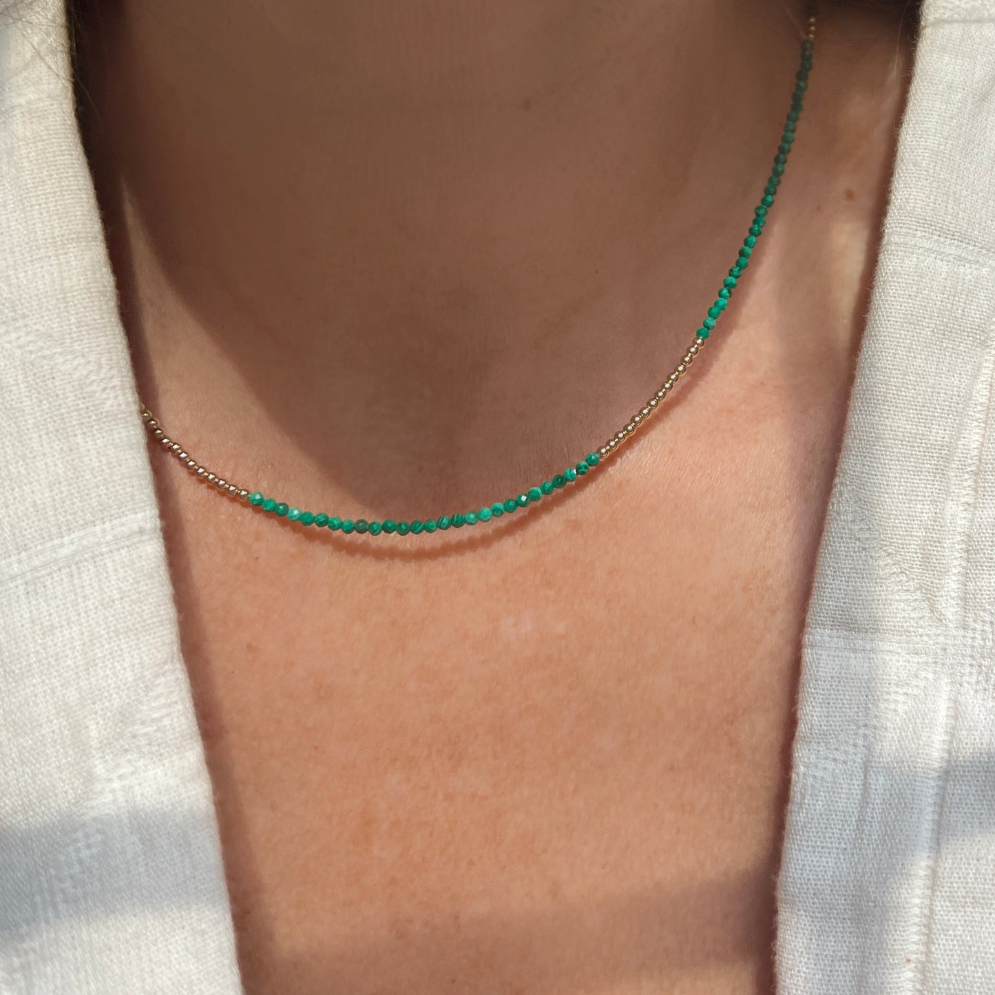 Luxurious malachite and 14K gold bead necklace, featuring rich green hues and a secure lobster clasp for a chic, sophisticated look.
