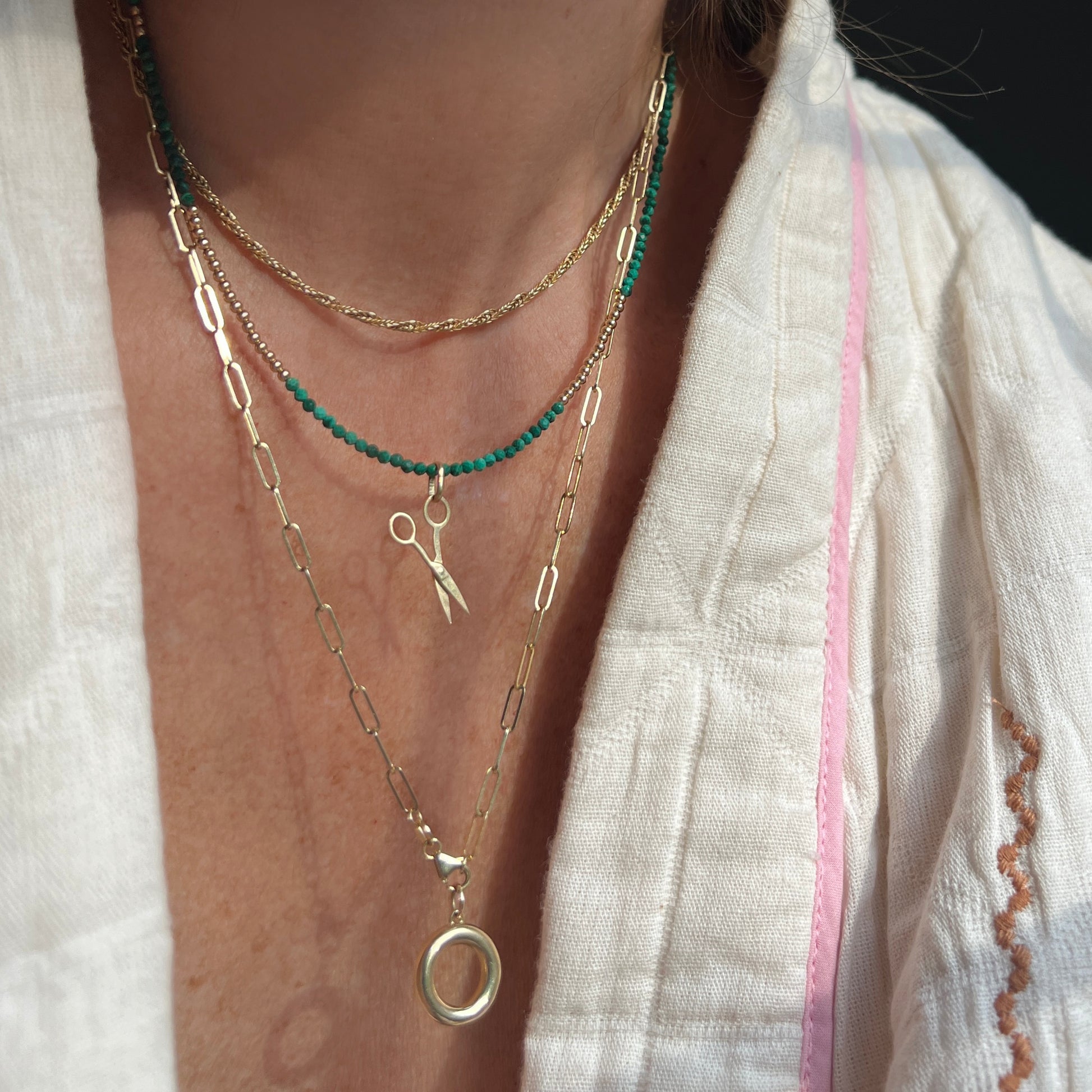 Faceted malachite and 14K gold bead necklace, a luxurious statement piece that can be worn alone for understated elegance or layered for a modern look.