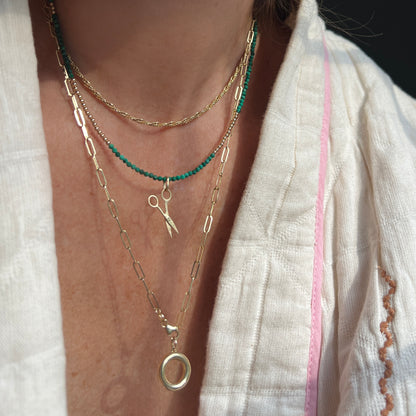 Faceted malachite and 14K gold bead necklace, a luxurious statement piece that can be worn alone for understated elegance or layered for a modern look.