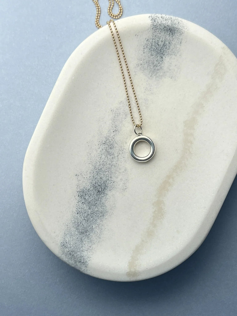 Crafted from premium 14K gold, the Circle Necklace symbolizes balance and endurance. Its minimalist design offers a meaningful statement of stability in a chaotic world.