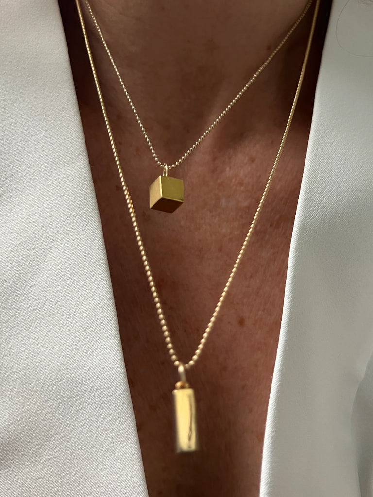 With its cube charm, this 14K Gold Cube Necklace embodies balance and endurance, a sleek and powerful talisman crafted for strength and stability.