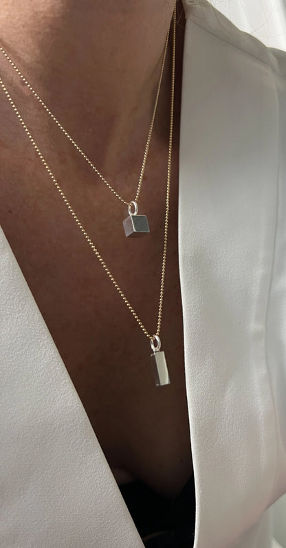 The 14K Gold Rectangle Necklace, with its clean, geometric design, symbolizes balance and organization, making it a timeless piece of elegance and purpose.