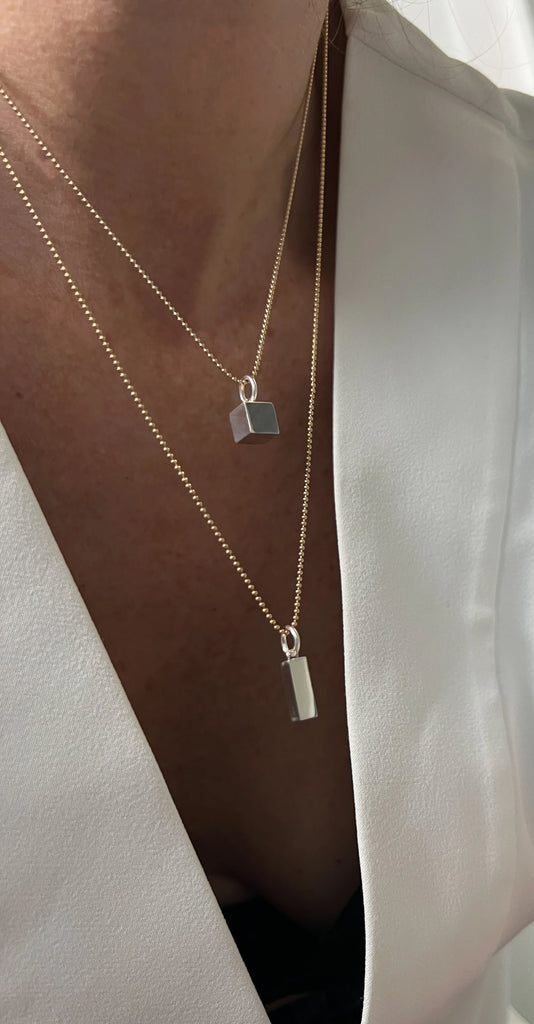 The 14K Gold Rectangle Necklace, with its clean, geometric design, symbolizes balance and organization, making it a timeless piece of elegance and purpose.