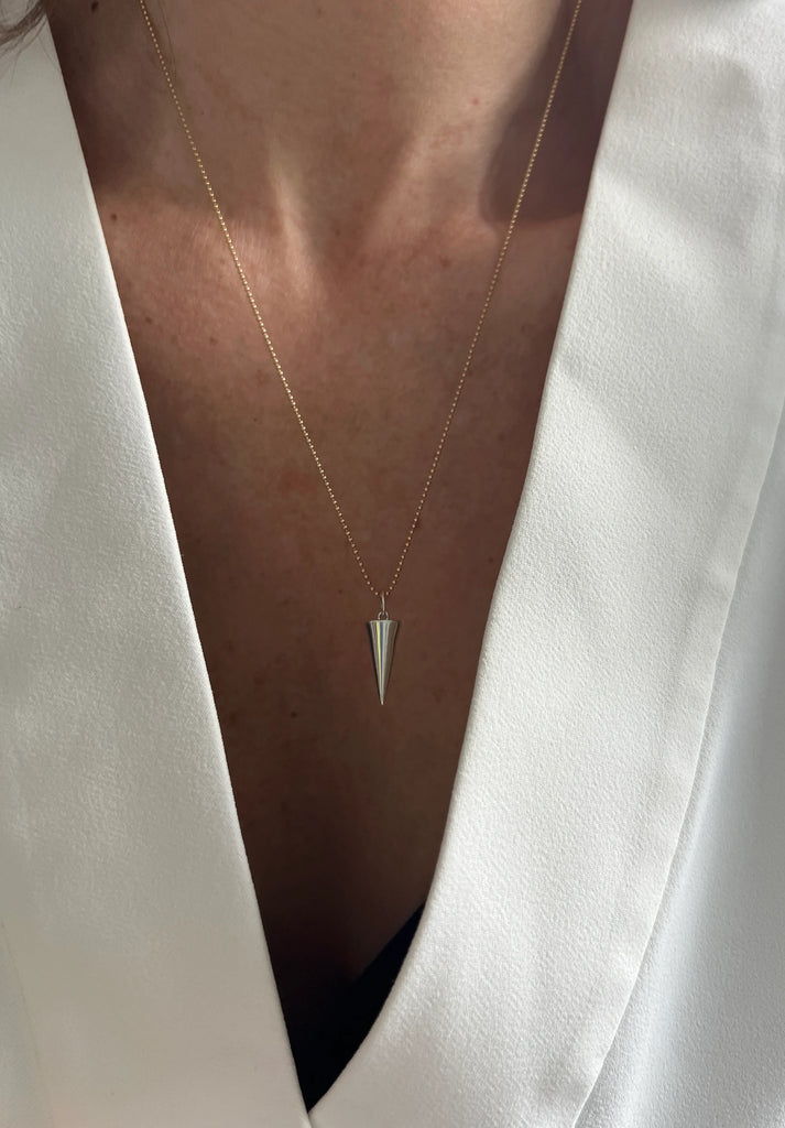 The downward-pointing triangle on the Zenith Necklace embodies intuition, nurturing, and creativity, making it a meaningful accessory from the Golden Geometry collection.