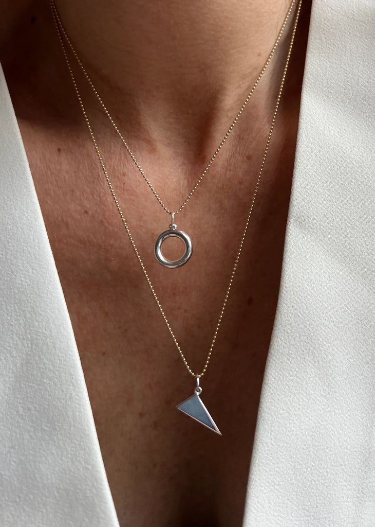 A tribute to individuality, the Scalene Triangle Pendant’s unequal sides represent authenticity and self-expression, crafted with precision in 14K gold or sterling silver.