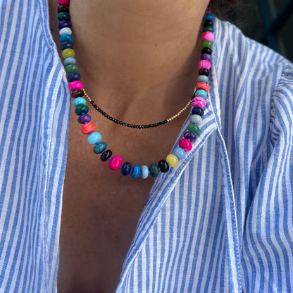 Model wearing a vibrant handcrafted gemstone necklace with 8mm opals, jade, turquoise, and more, accented with Czech glass beads and a sterling silver clasp.